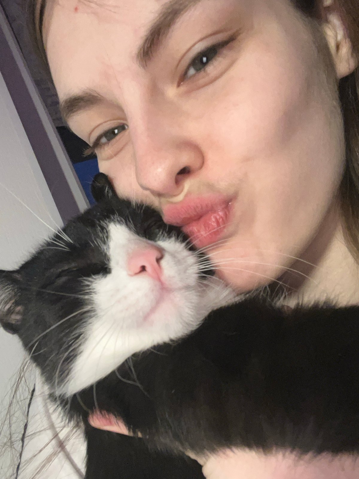 Person shares intimate moments with black and white cat
