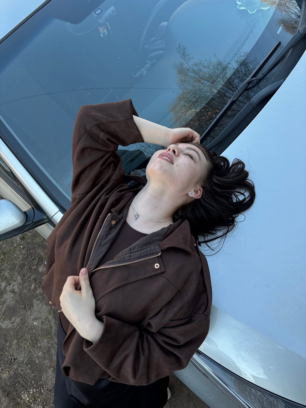 Woman rests on car hood in Perm, Russia