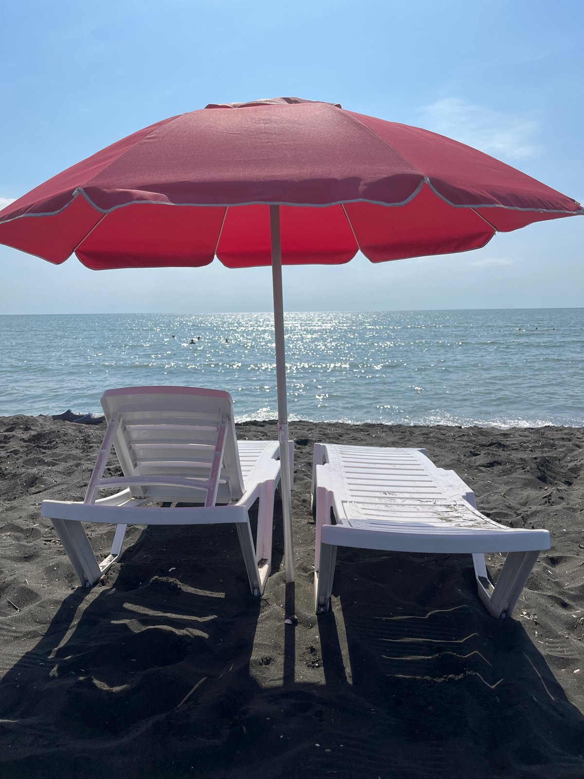 Ureki's black sand beach: chairs, shells, and shoreline details
