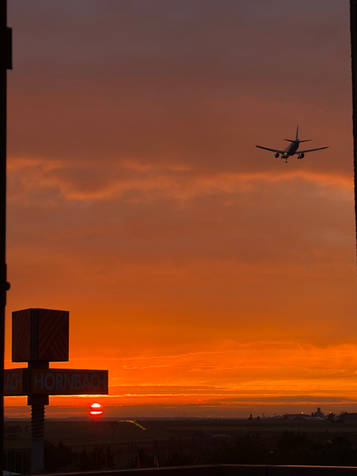 Prague sunset with airplane, shot through window and open sky