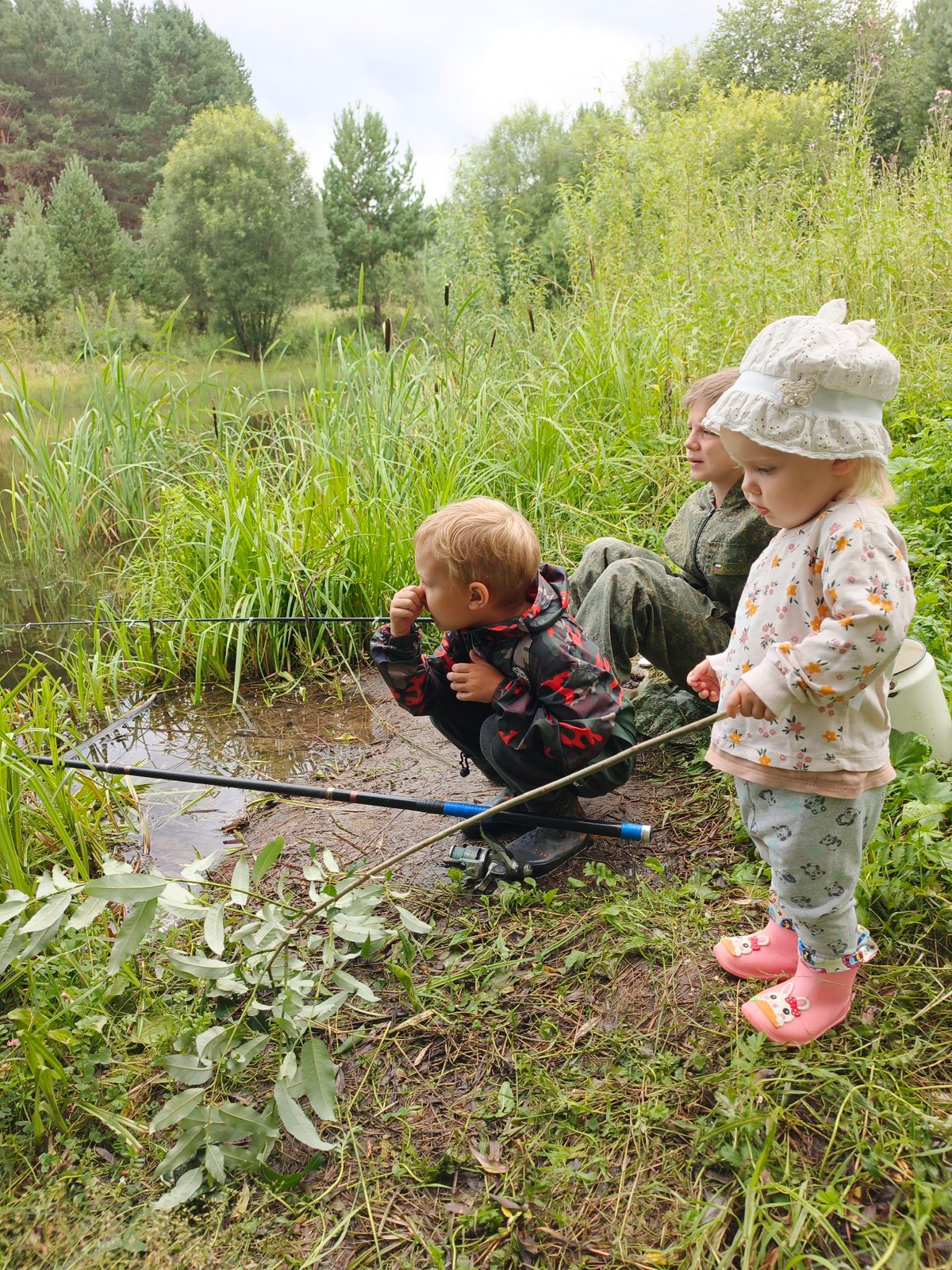 Kids fishing a rural Russian lake, wildflowers all around