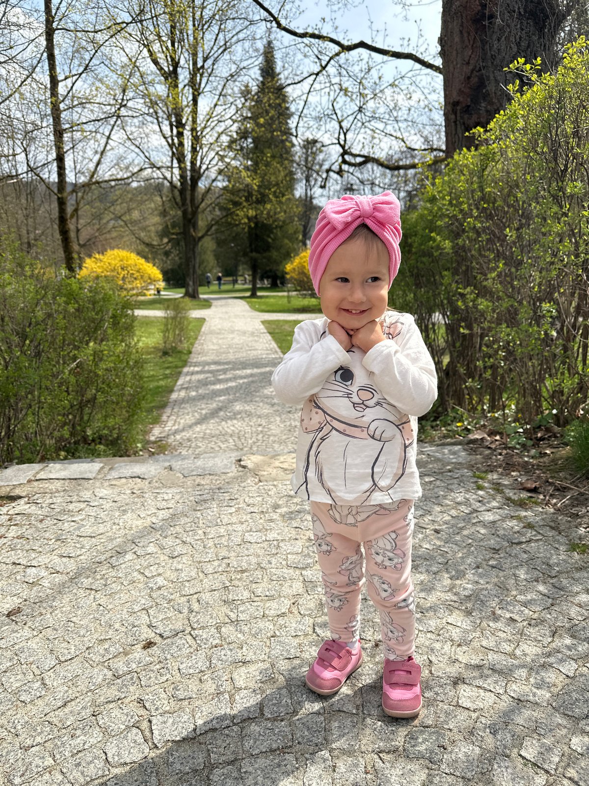 Child enjoys spring morning in Wisła park amid blooming shrubs