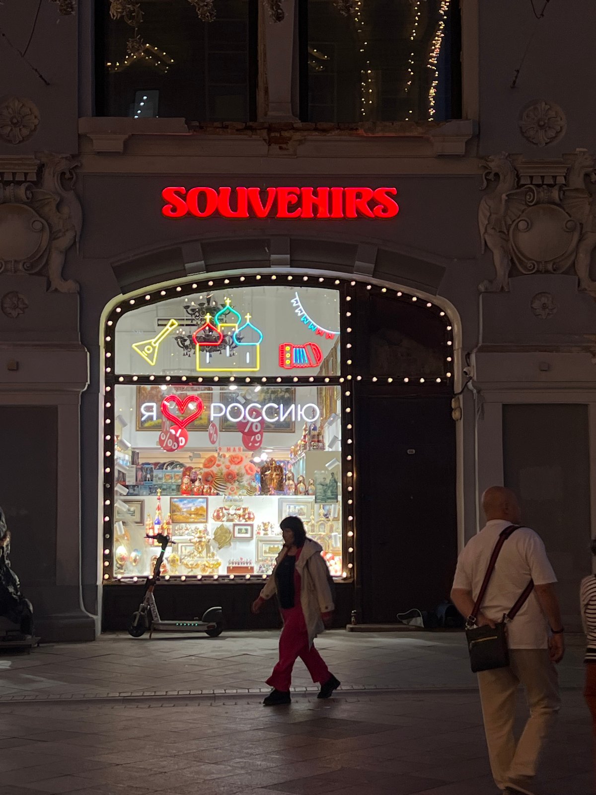 Dance group rehearses on illuminated Moscow street at dusk