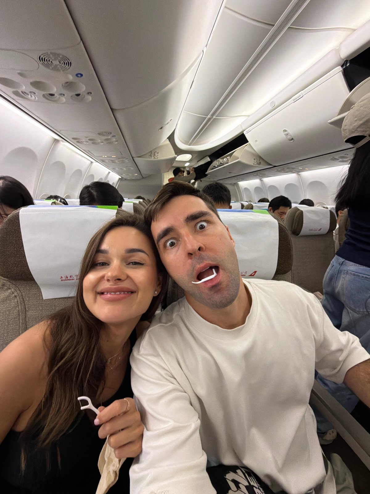 Airplane passengers take playful selfie with makeshift dental floss fangs