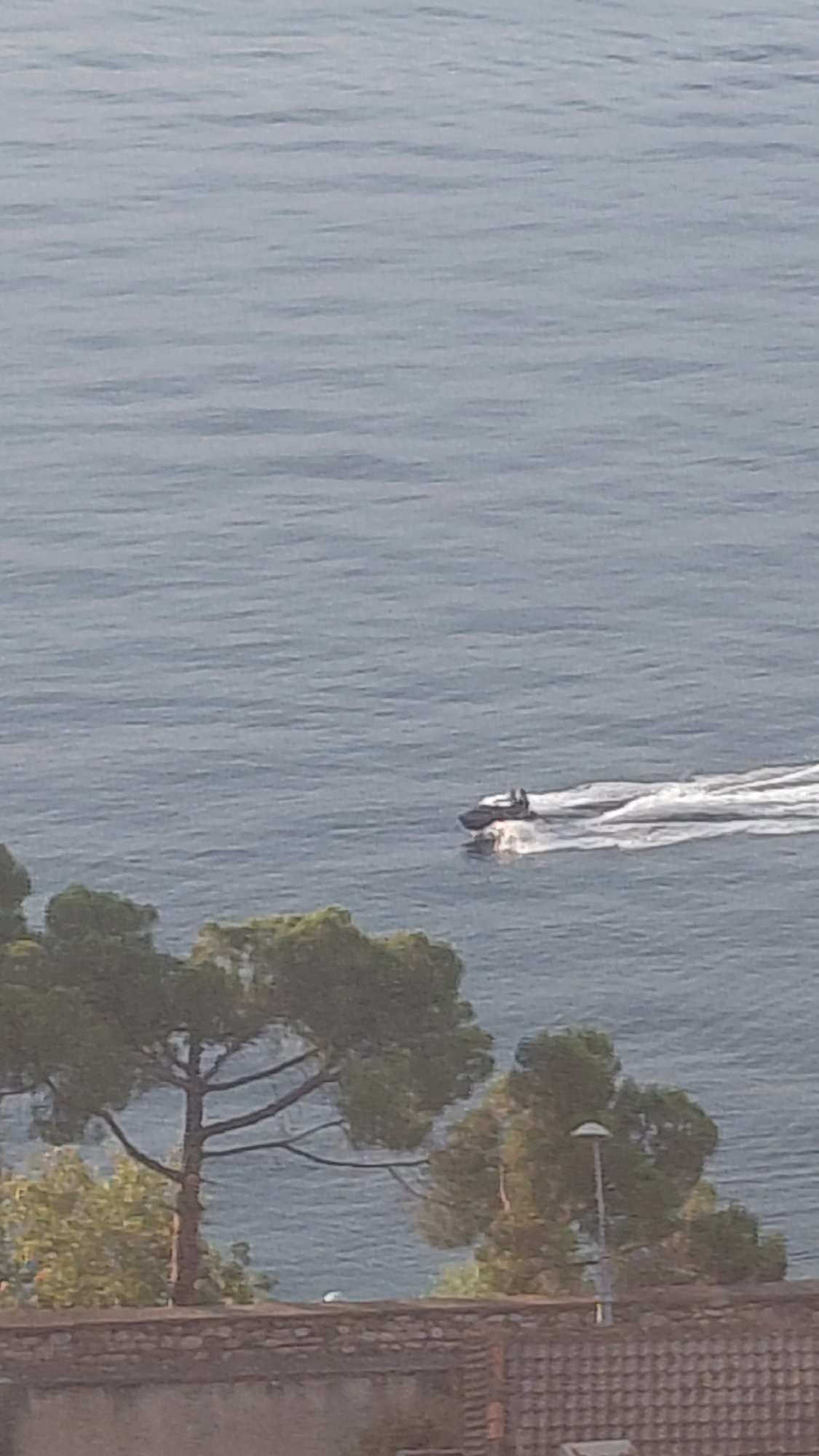 Jet ski on calm water, cat candles melting nearby in Aegio