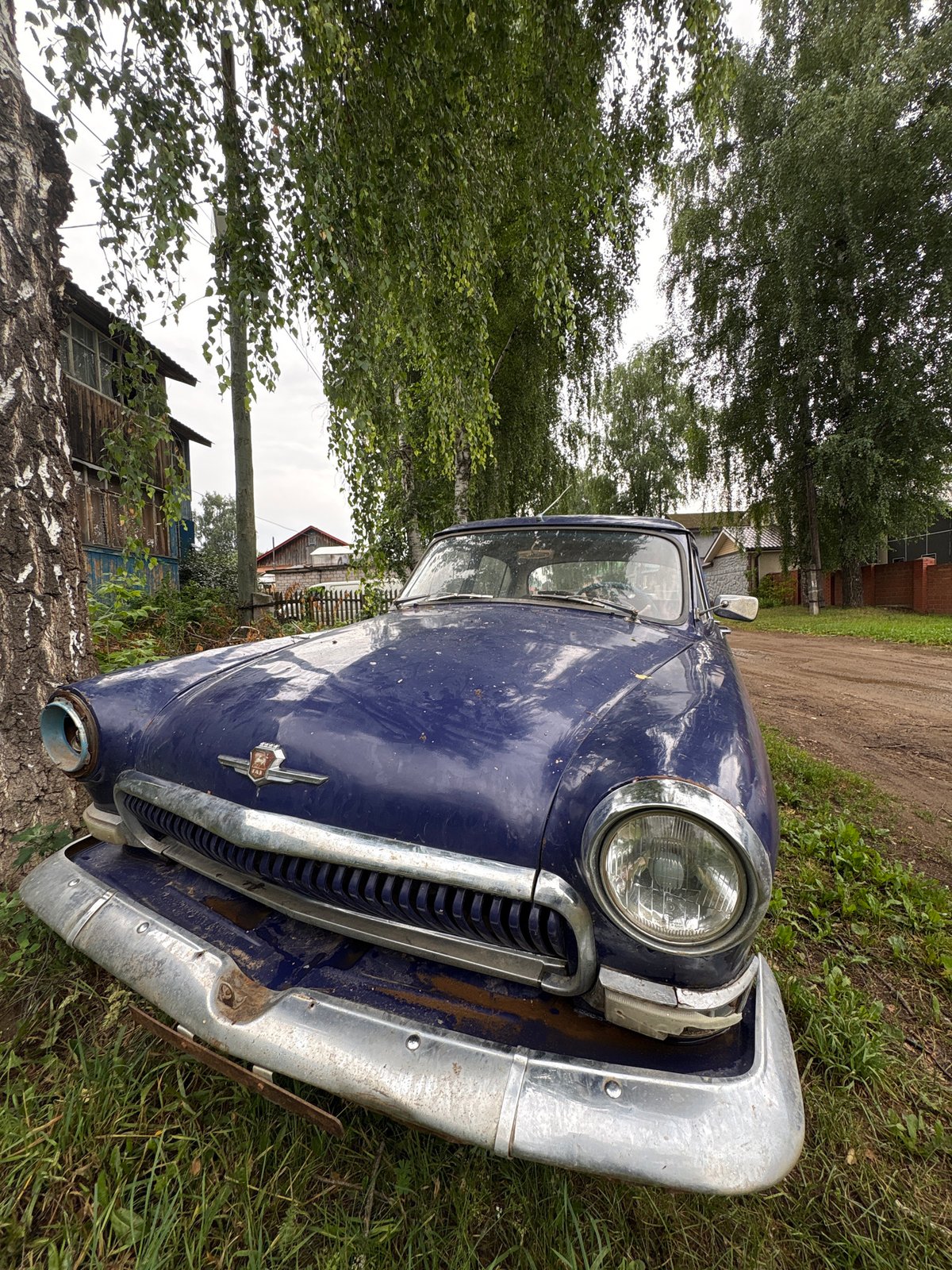 Vintage blue car parked roadside in Chaikovsky, Russia