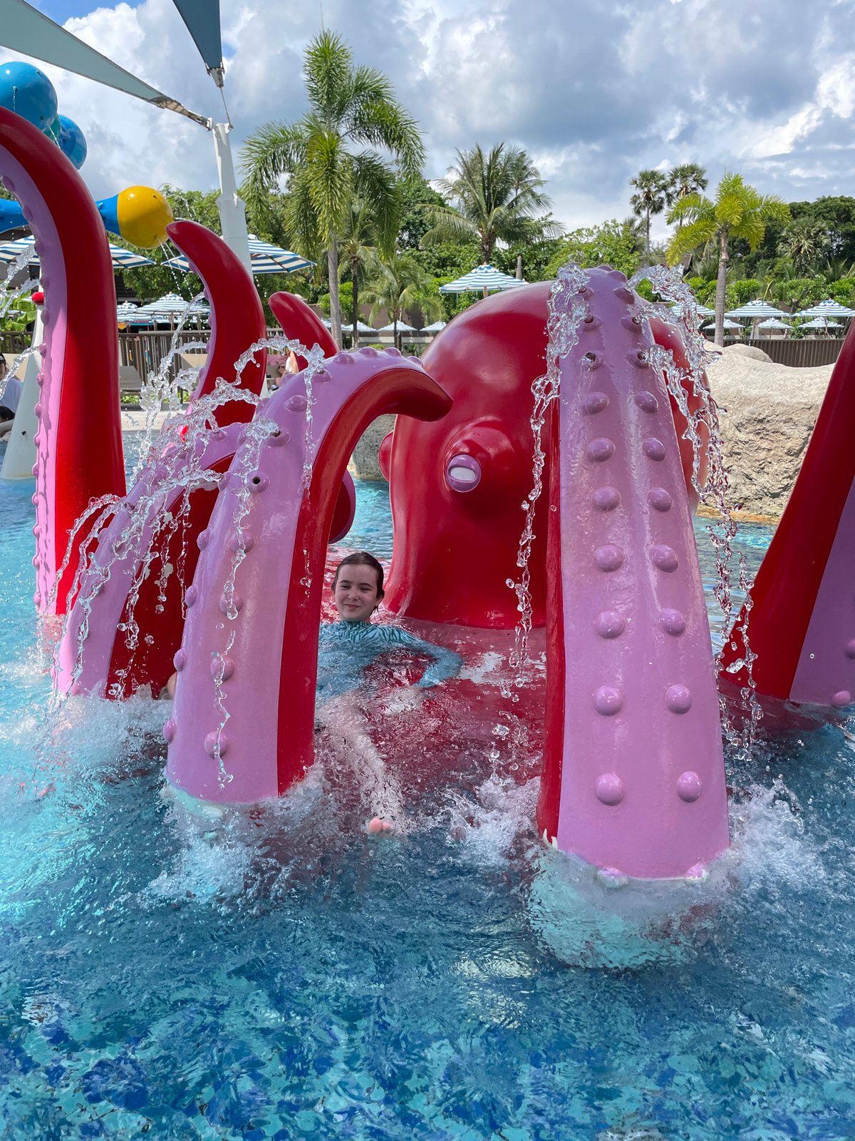 Swimmer plays with octopus water feature at Thai water park