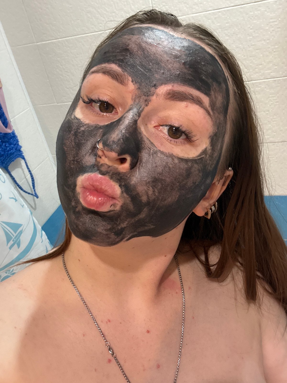 Woman documents self-care routine with facial mask, bubble bath