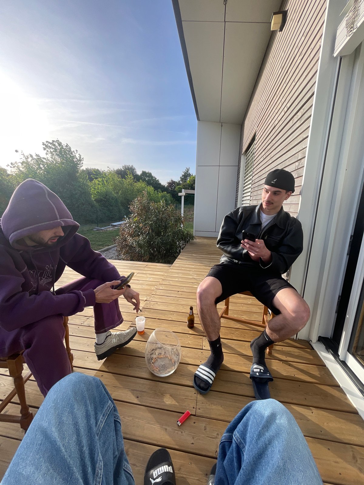 Two men sit on deck in Thénezay during afternoon