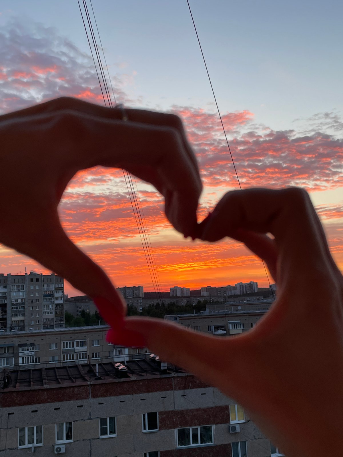 Sunset photography session captures Izhevsk skyline with heart gesture