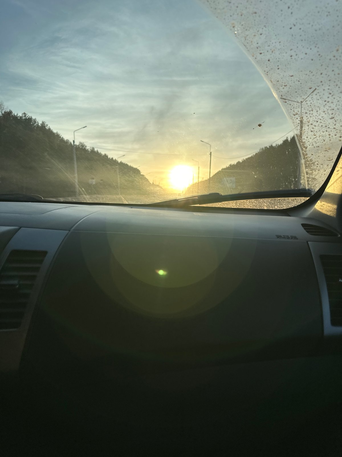 Vehicle travels rural road during sunset in Shud'ya, Russia