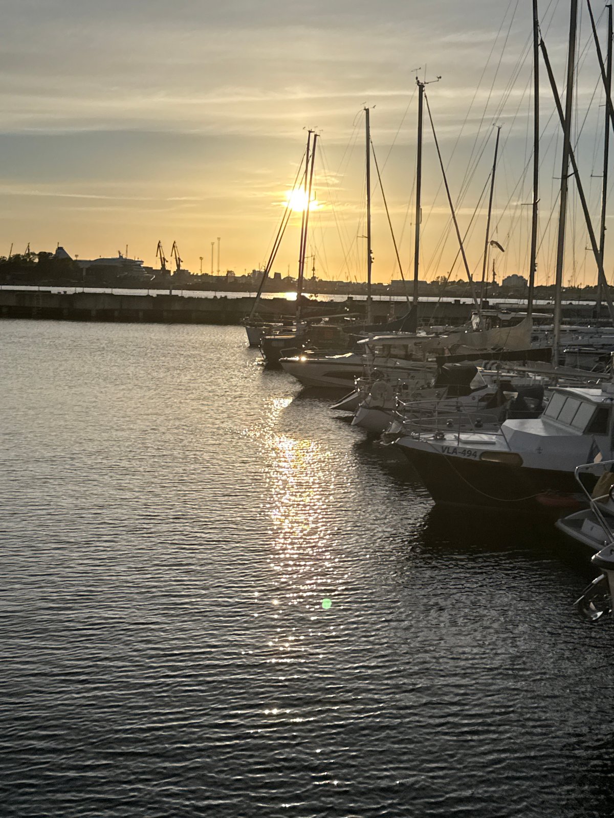 Sunset documented at Tallinn Harbor with boats and waterfront activity
