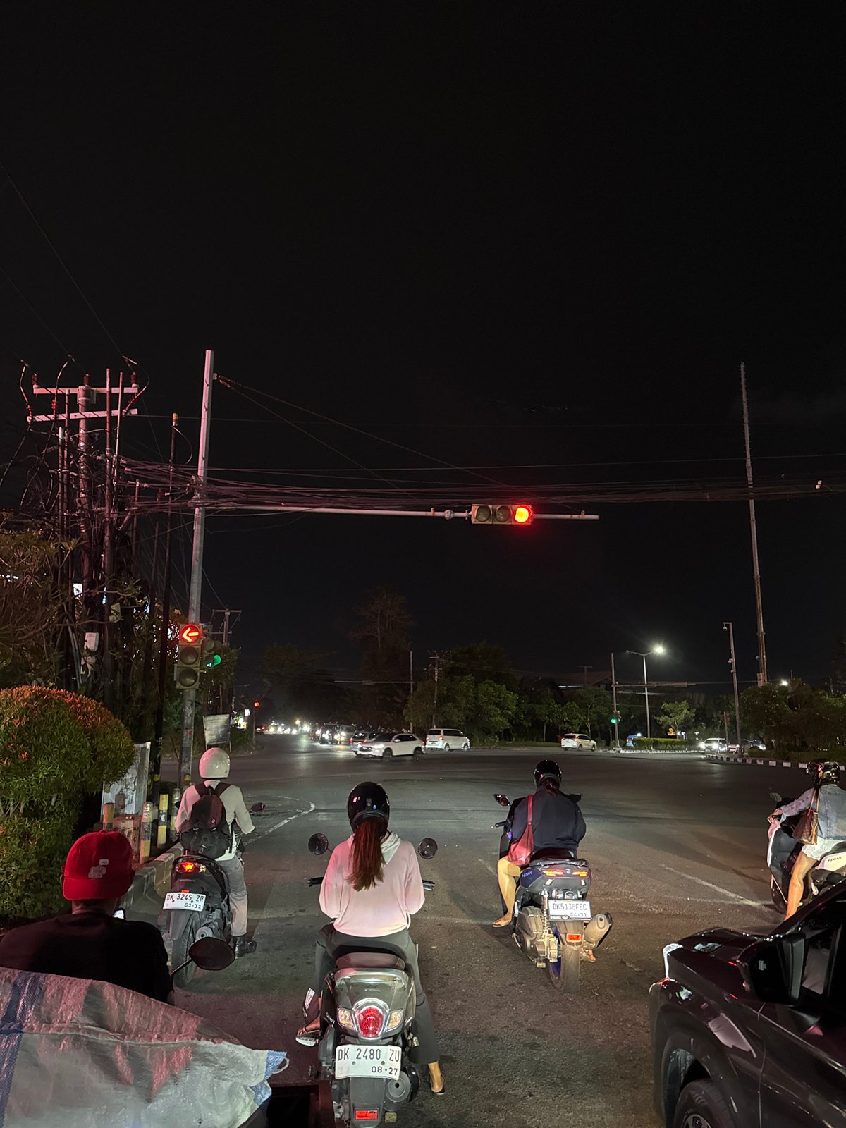 Late-night traffic and a neon party bus rolling through Kuta