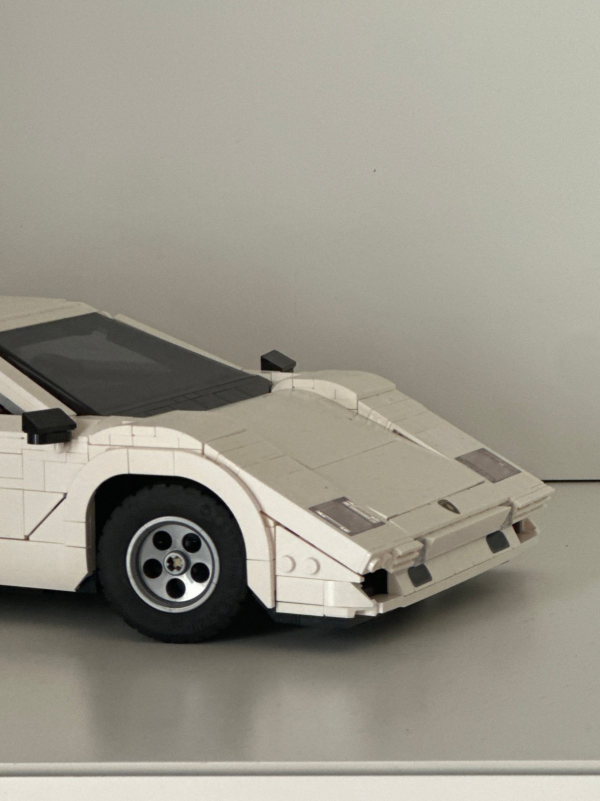 White LEGO-style vintage car model spotted upright in Milan