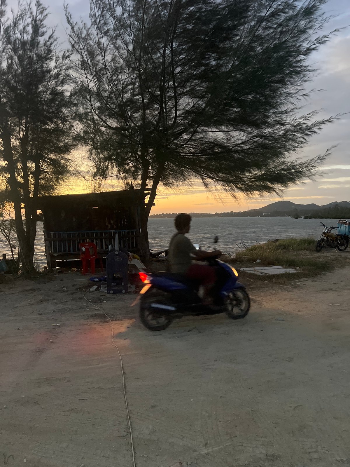Dusk along Ko Pha-ngan's coast, boats, bikes, and shoreline