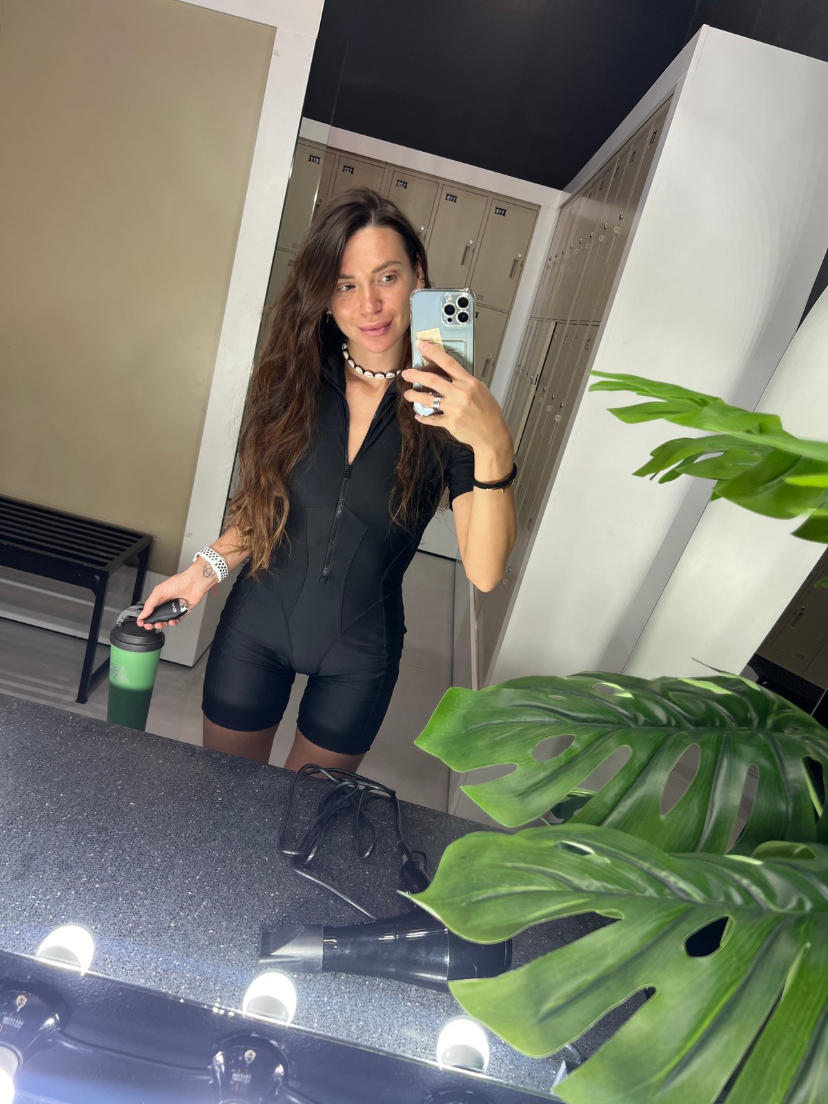 Woman takes locker room selfie with water bottle and phone