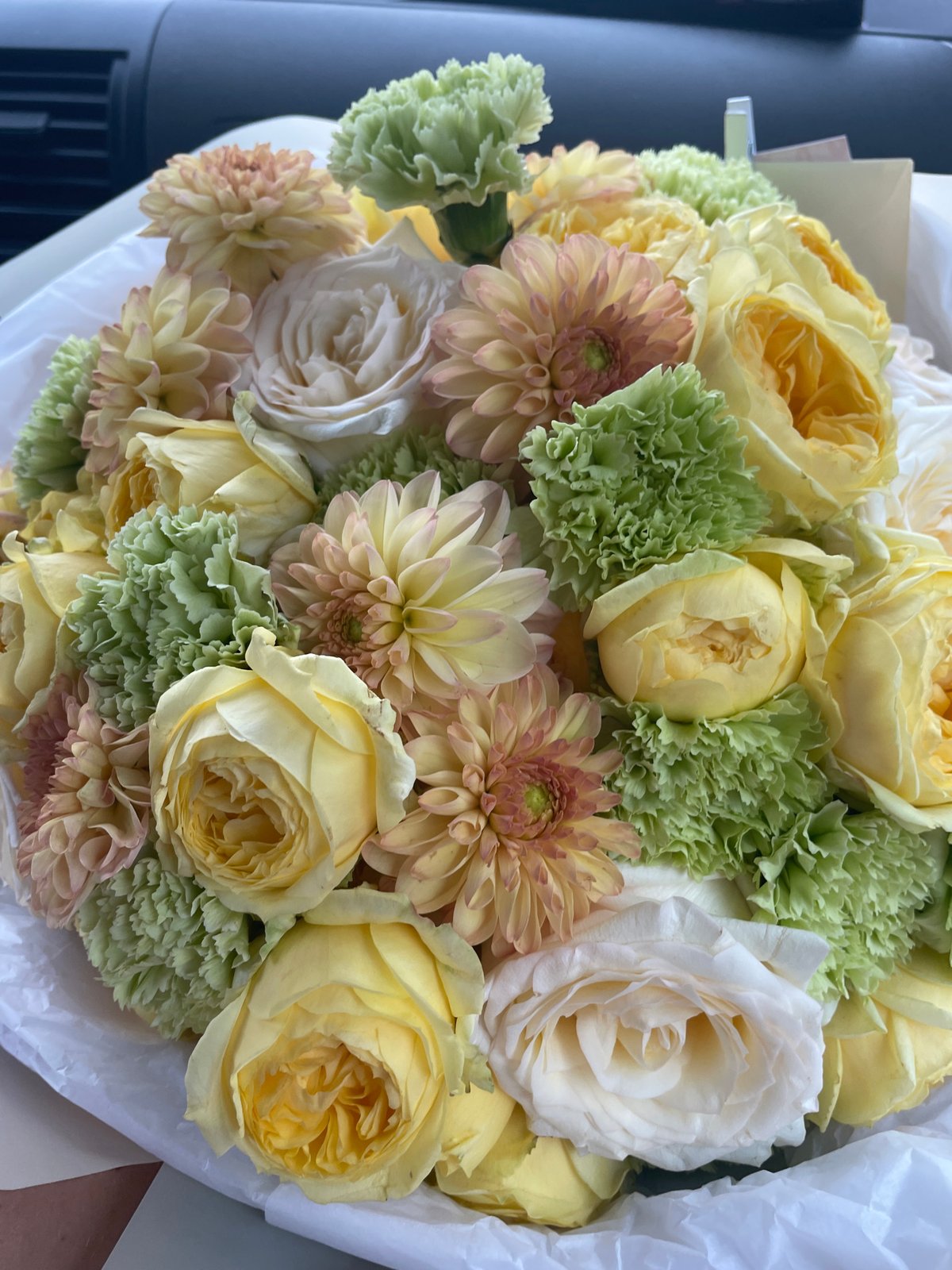 Mixed bouquet of roses and dahlias, wrapped and ready to go