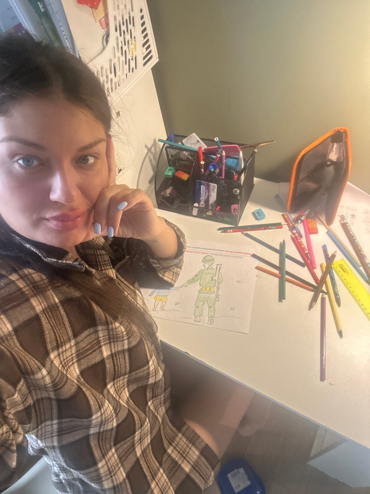 Woman takes selfie at art supply-filled desk in Khimki