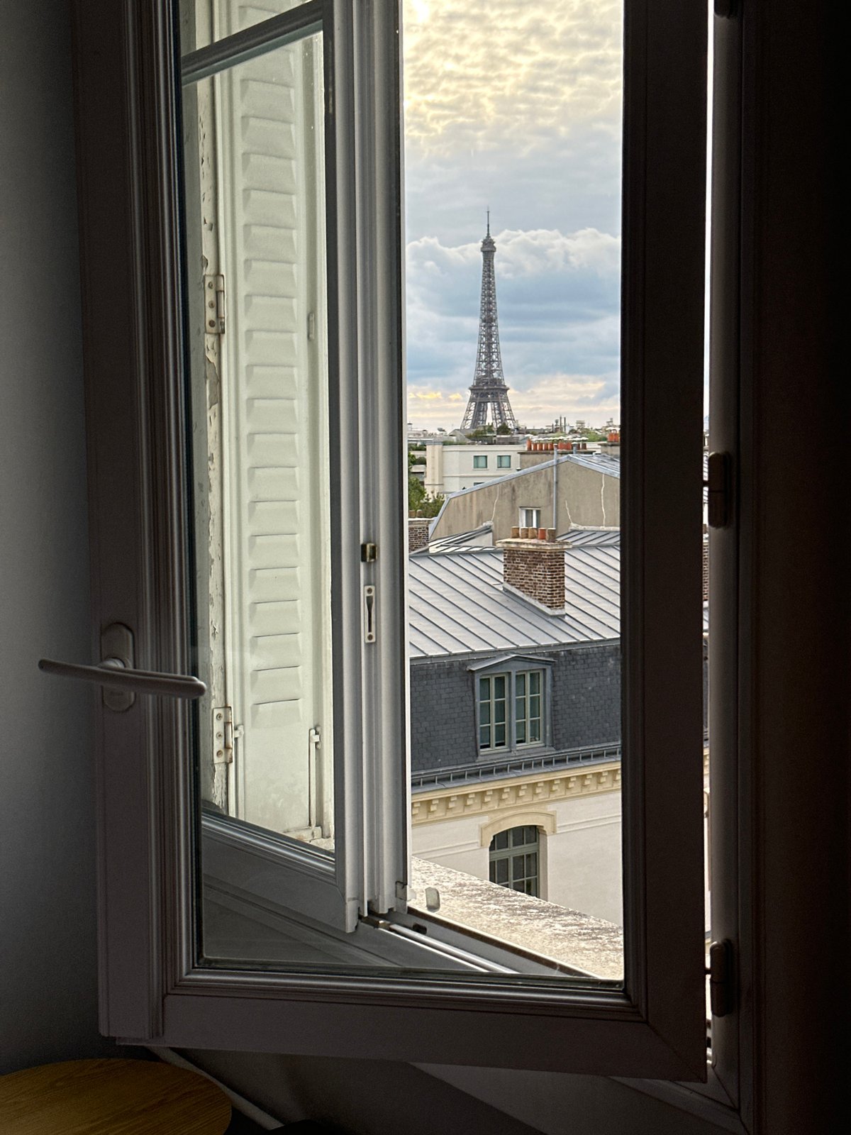 Window views capture Paris rooftops and Eiffel Tower evening scenes