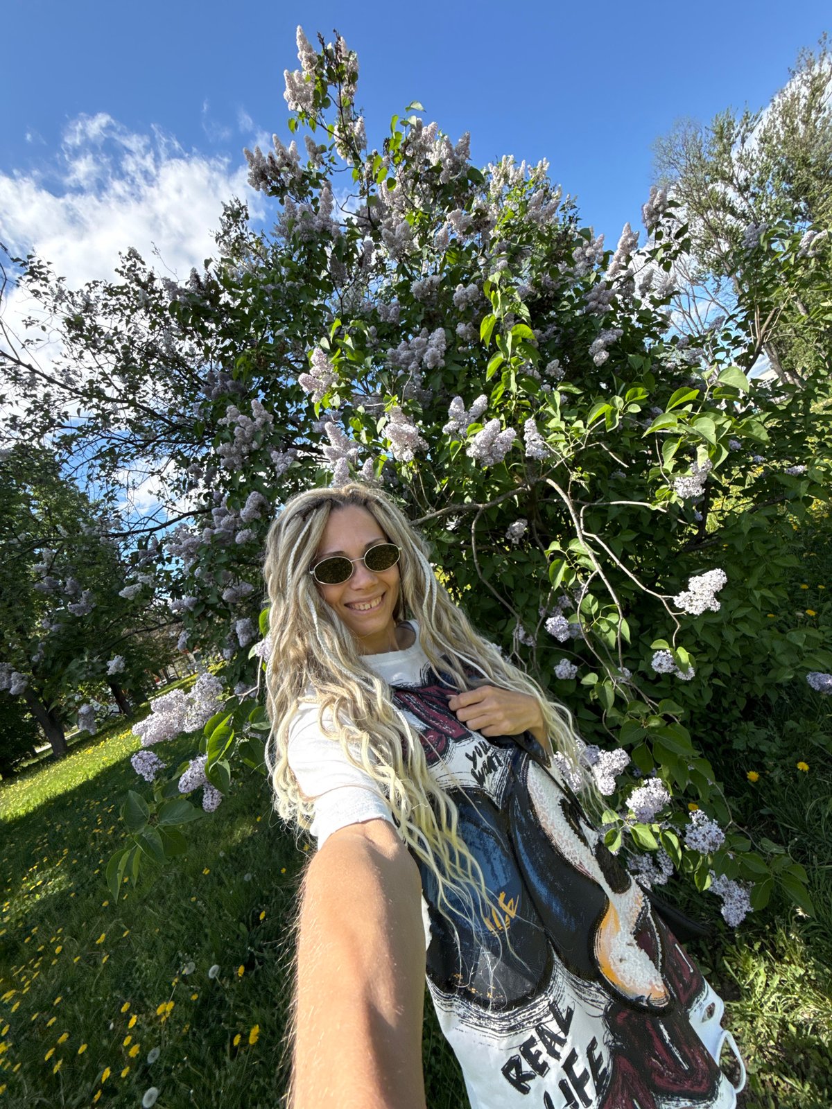 Woman enjoys spring morning among lilac blooms in rural Russia