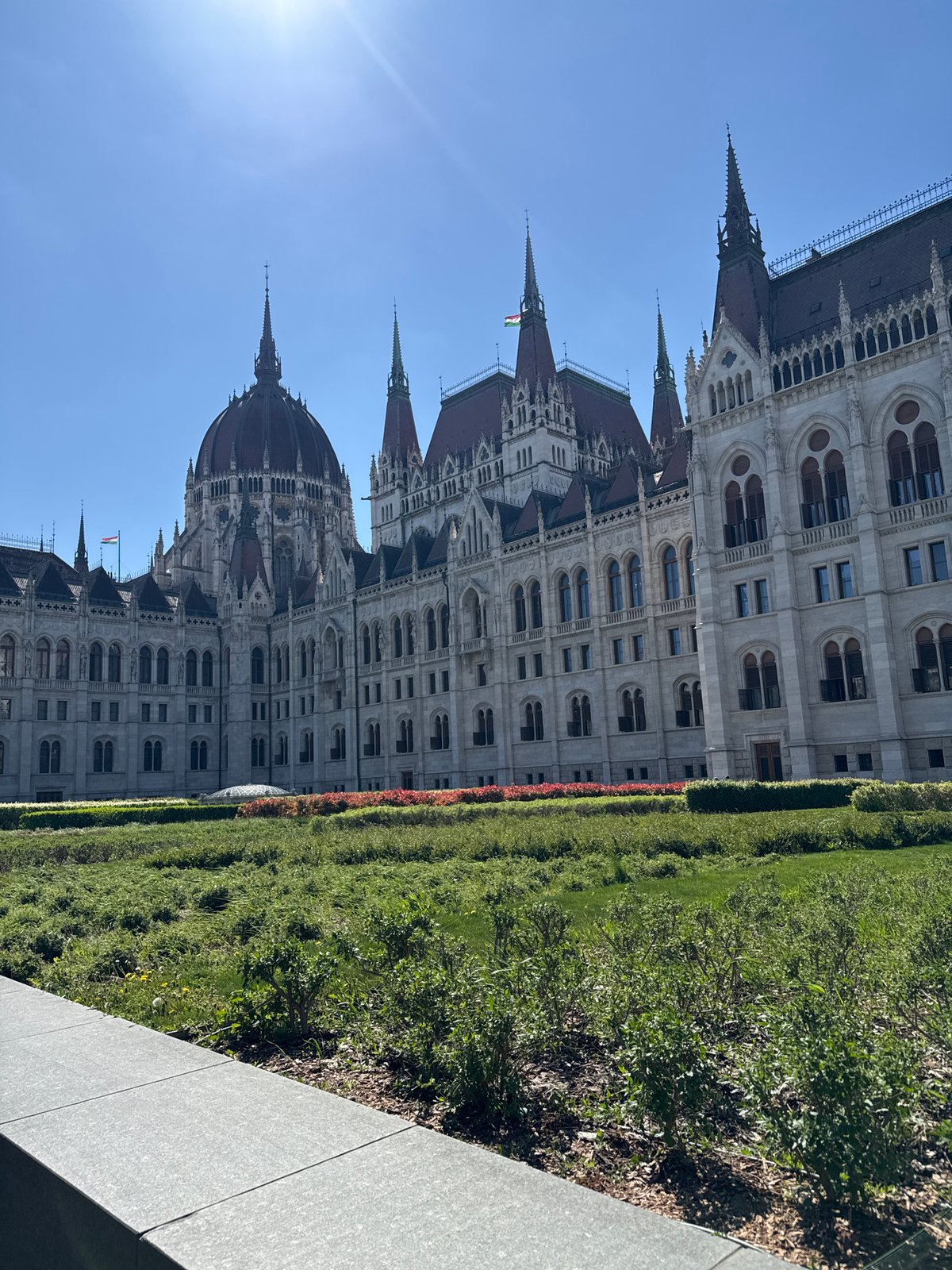 Tourist photographs capture Budapest Parliament Building on sunny afternoon