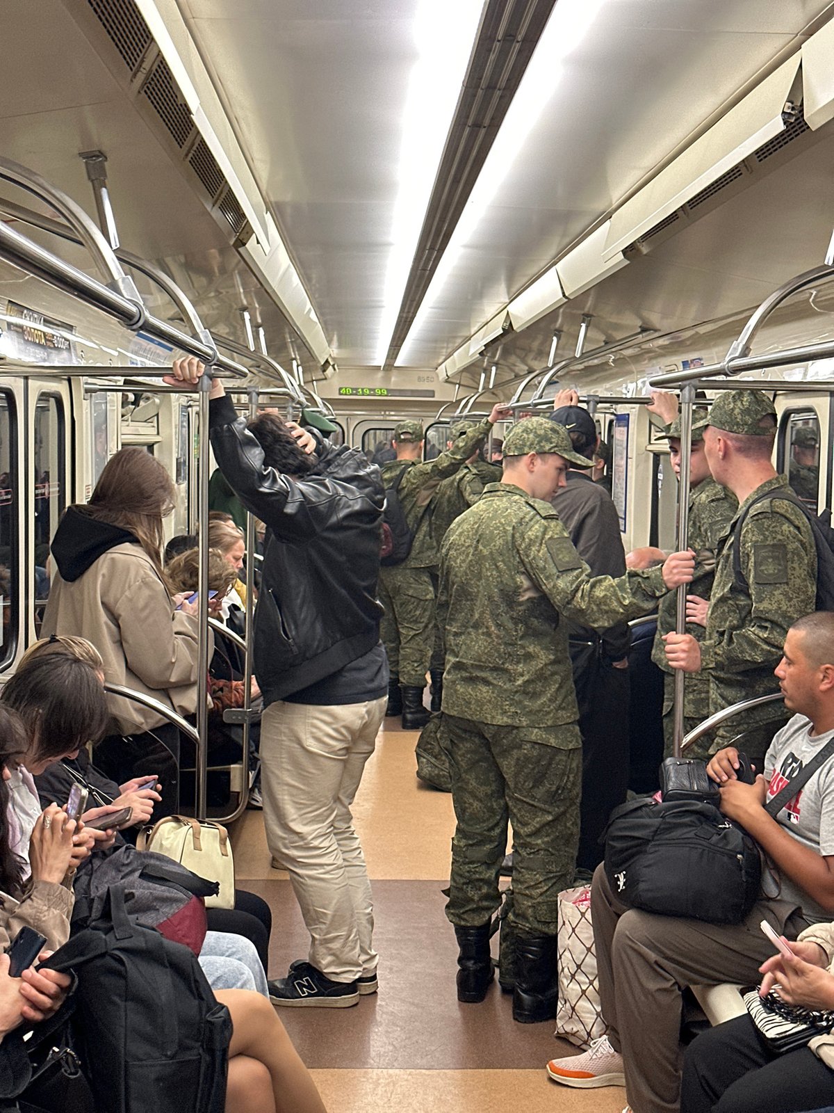 Civilians and military personnel ride the Saint Petersburg Metro together