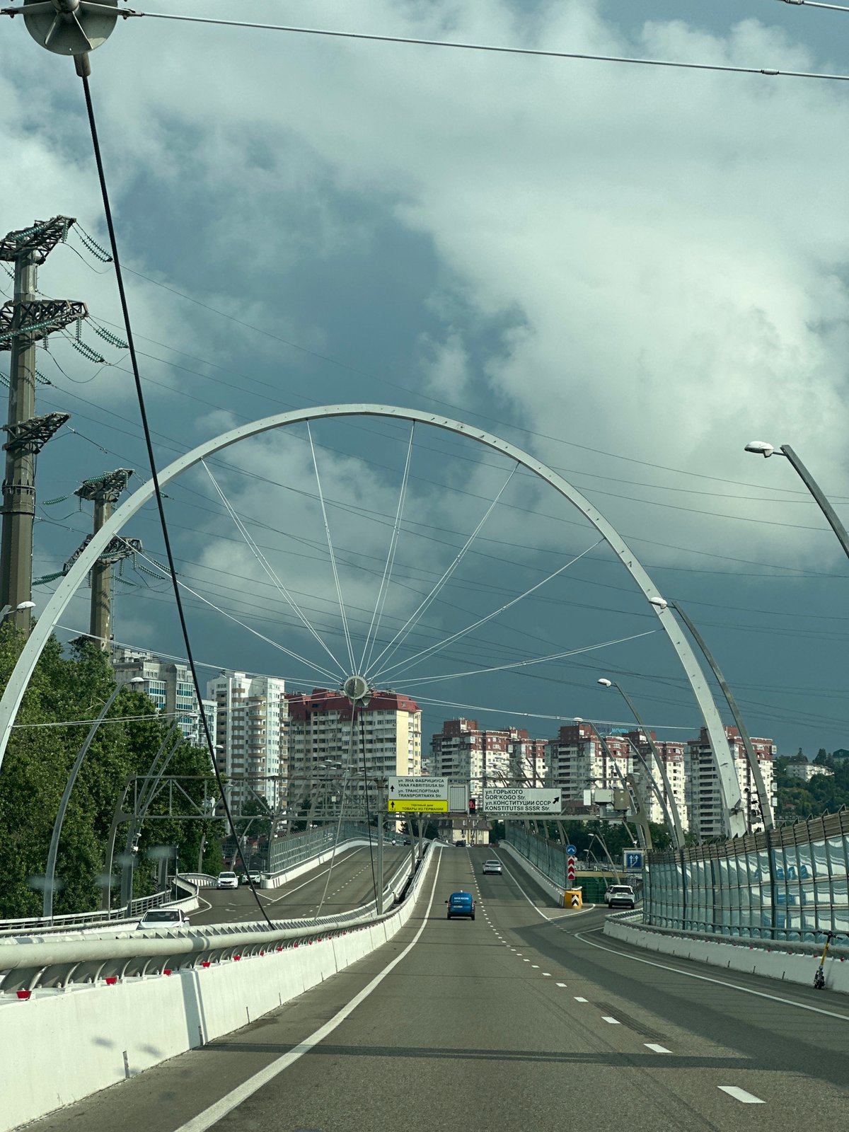 Arched highway overpass in Sochi, midsummer traffic flowing through