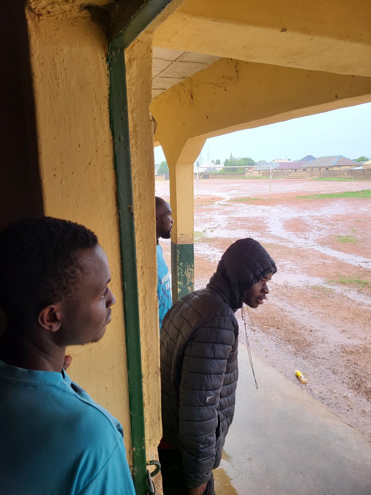 Young men gather for outdoor sports on dirt field