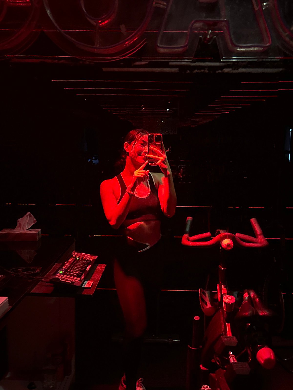 Woman poses for photos at red-lit cycling studio in Puebla
