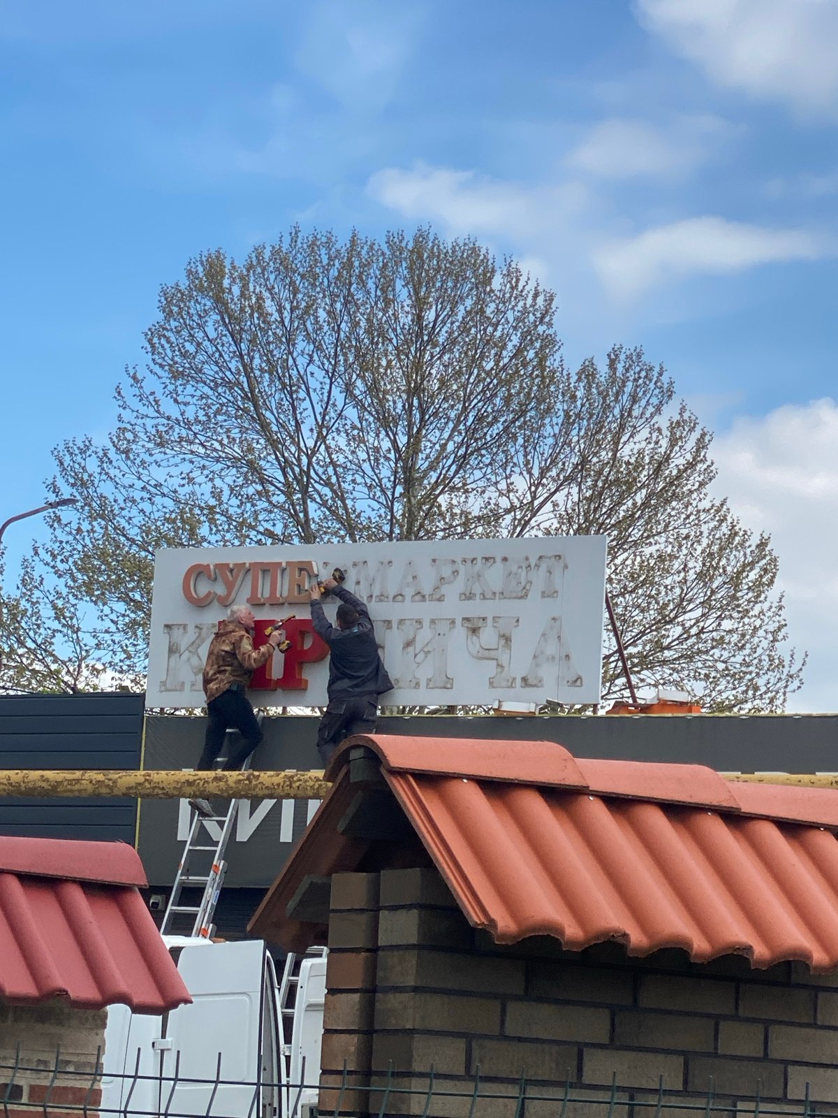 Russian supermarket sign installation amid ongoing construction activity