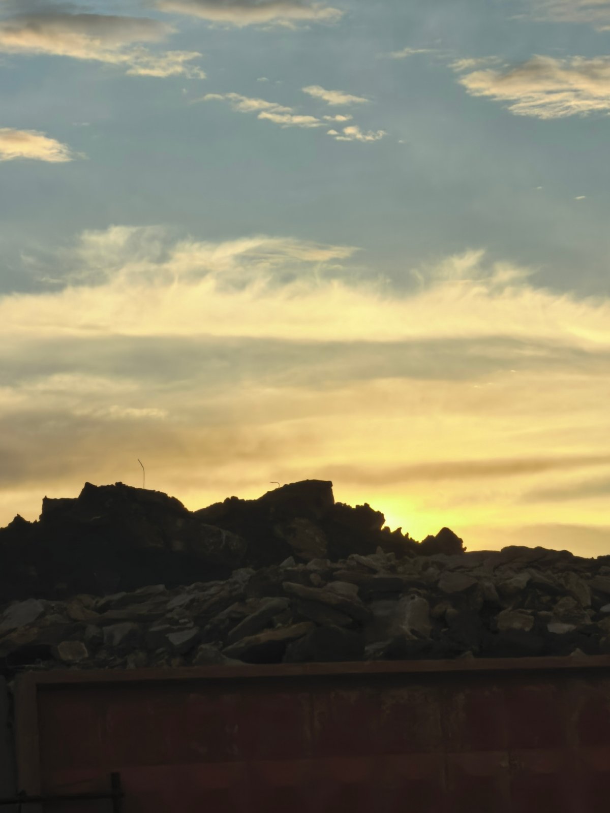 Urban sunset with people, scooters, and construction sites