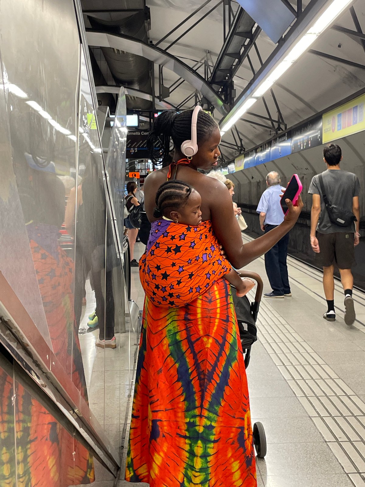 Waiting on a Barcelona metro platform, headphones on