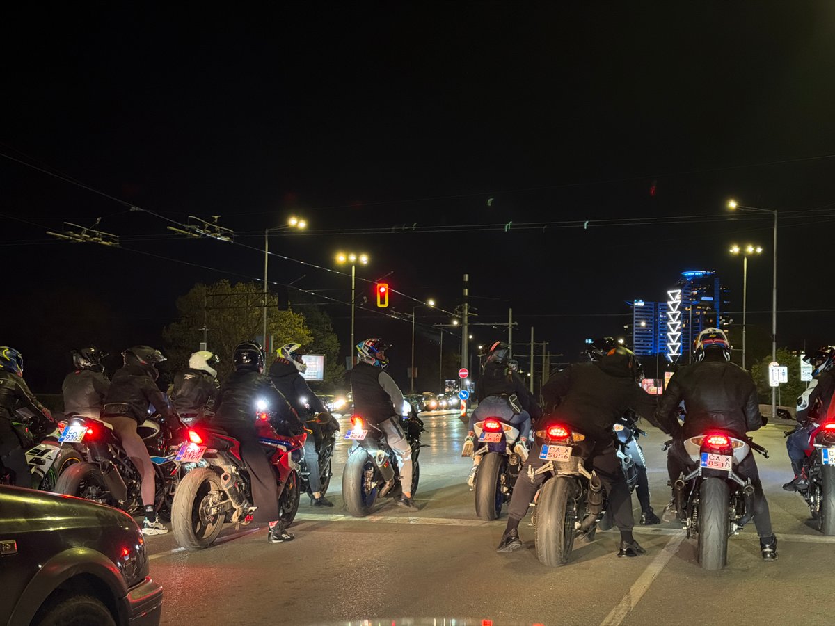 Motorcycle group stops at Sofia intersection during evening hours