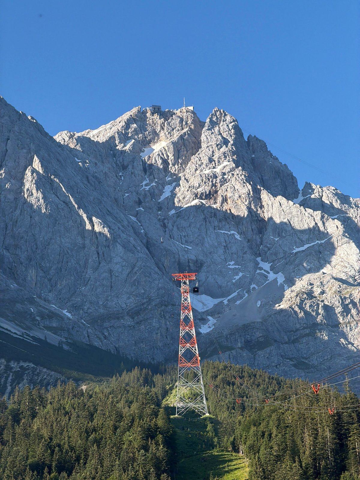 Cable car tower under blue skies in the Bavarian Alps