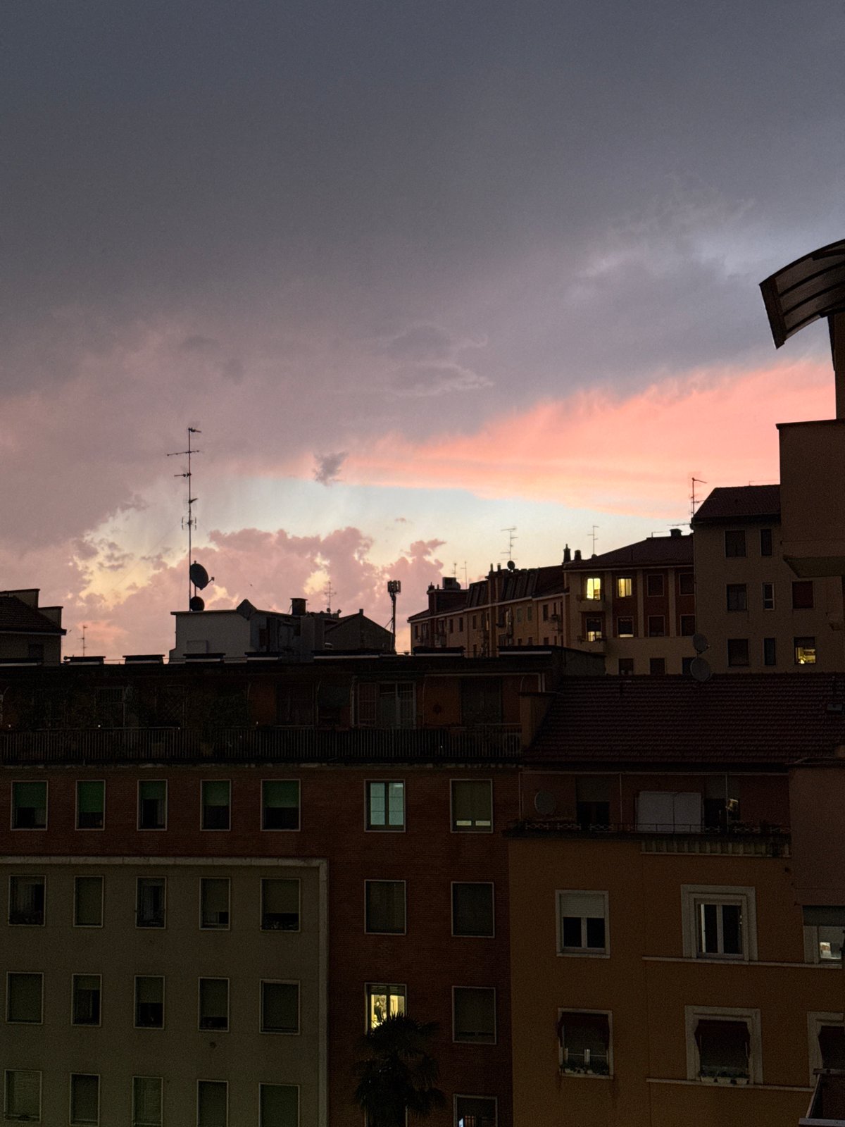 Dramatic sunset illuminates rainy Milan evening across multiple neighborhoods