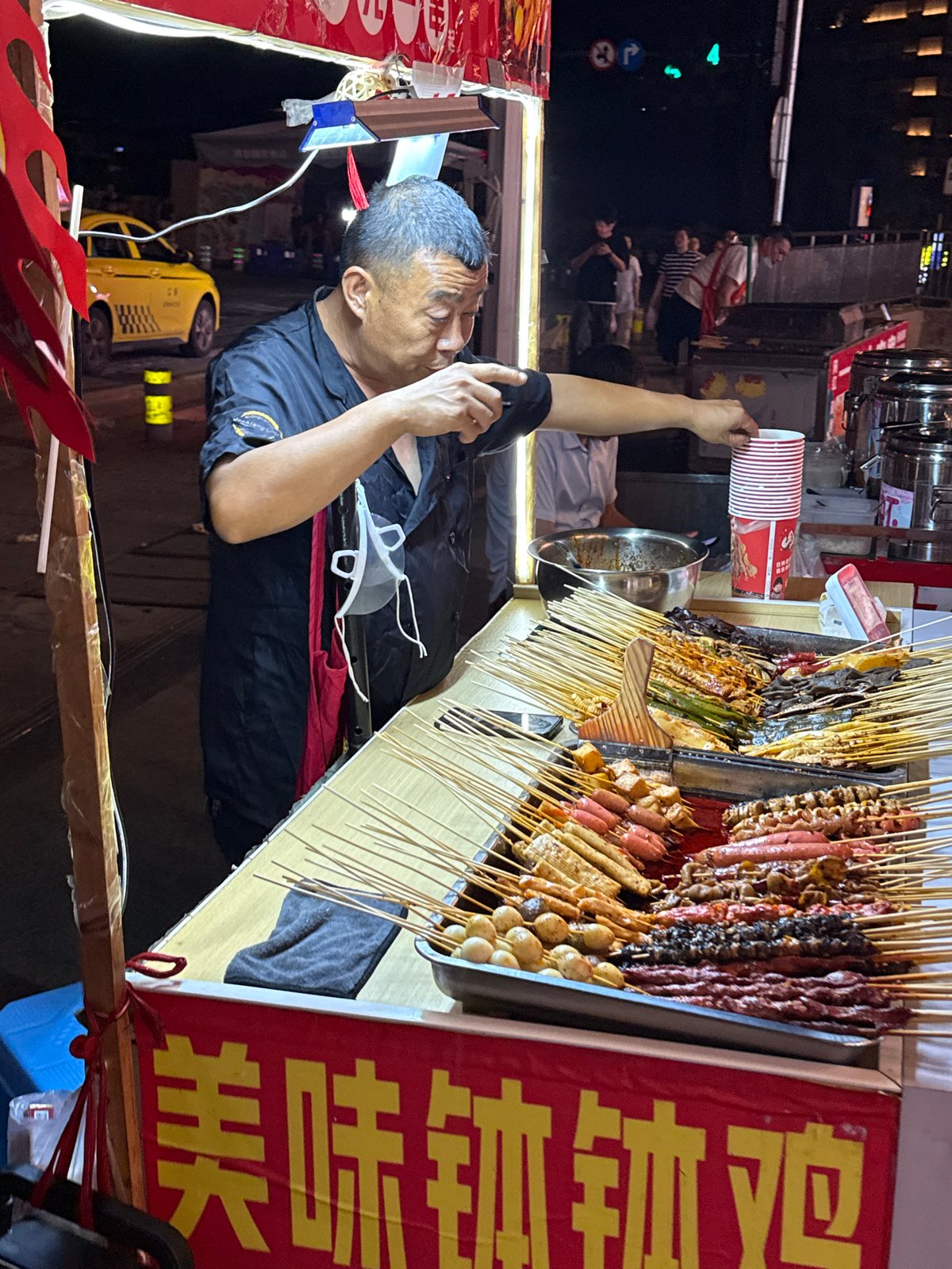 Night market activity along a lit traditional street in Shapingba
