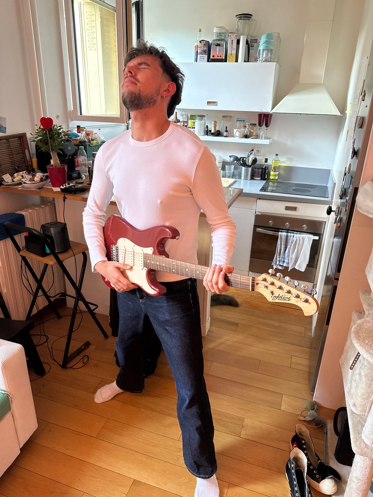 Man plays electric guitar at home in Paris