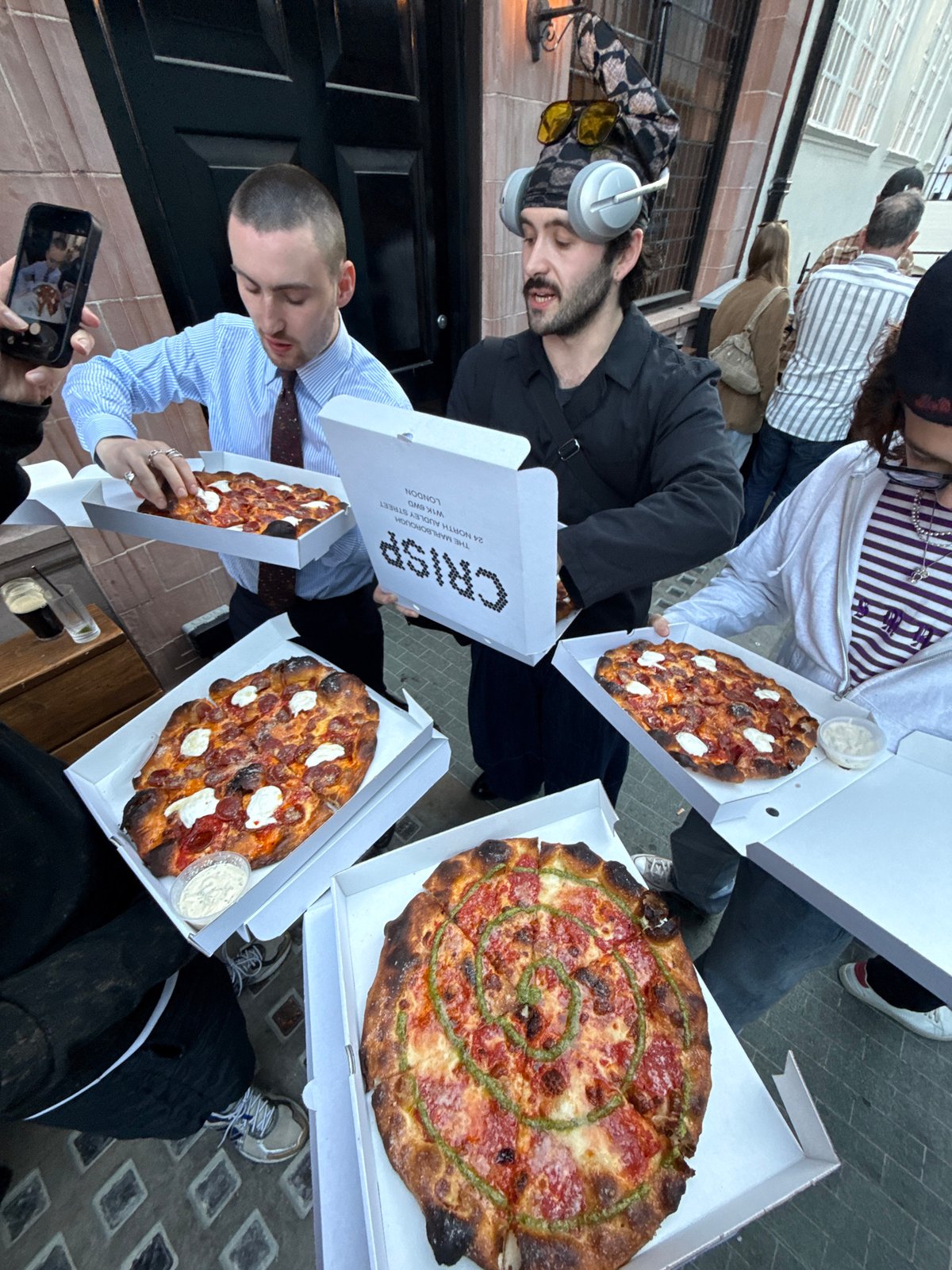 Group gathers with fresh pizzas on London street