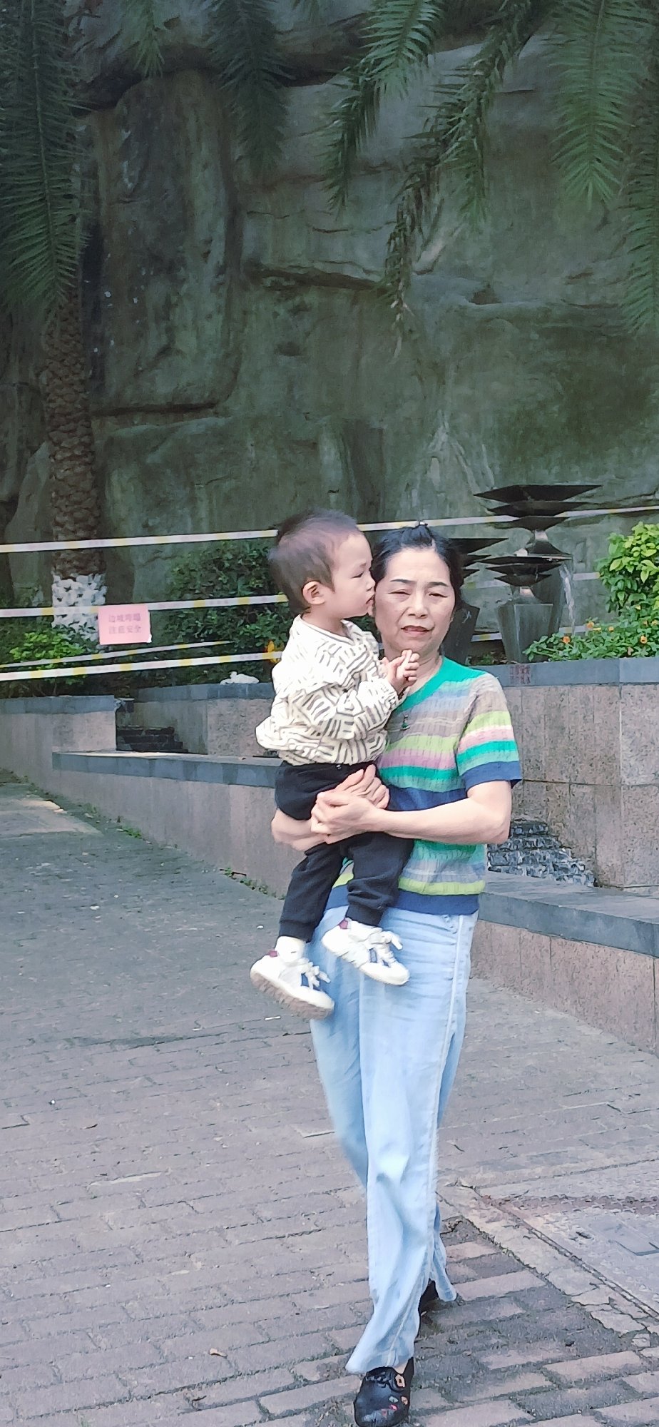 Mother and child walk tree-lined sidewalk in Jiulongpo District