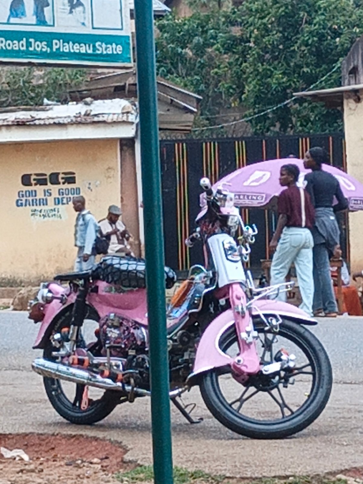 Evening street life captured around outdoor pool game in Jos