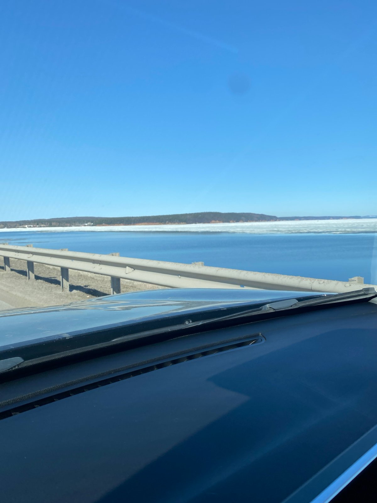 Vehicle crosses bridge over icy Kama River in Chaikovsky