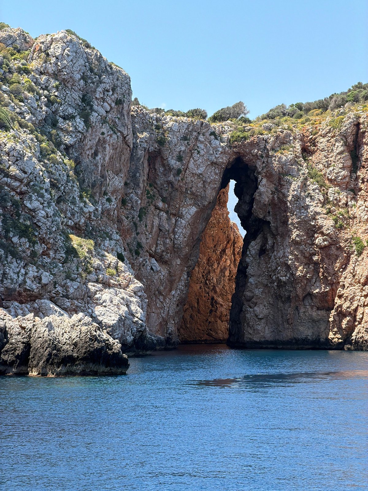 Turkish coastal boat tour navigates dramatic cliffs and natural arches