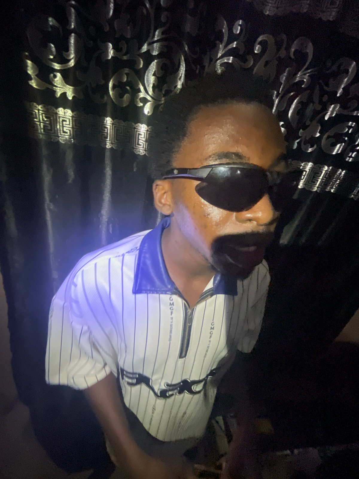 Man in designer streetwear photographed resting indoors in Lokoja