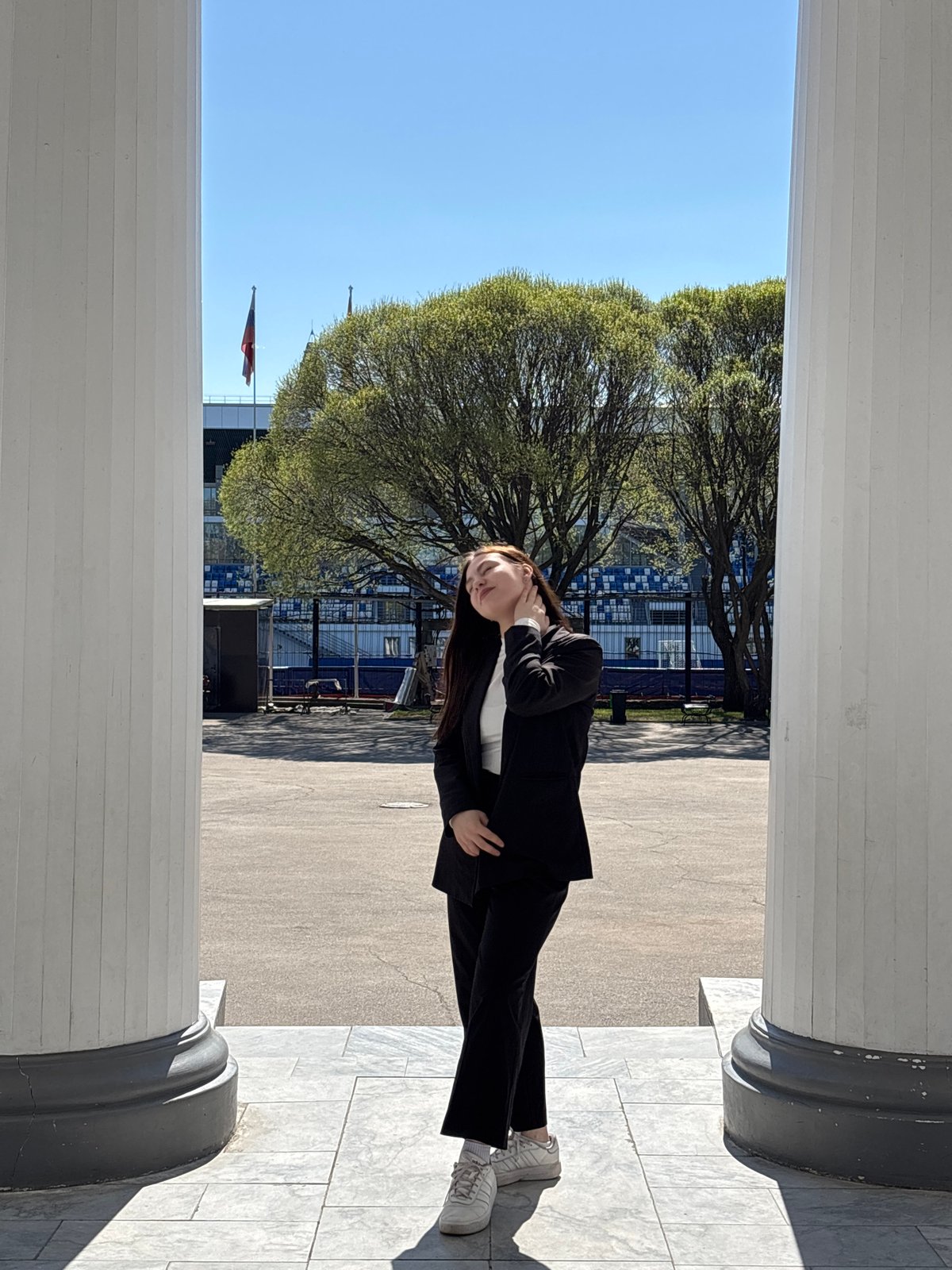 Woman in business suit photographed at marble columns in Perm