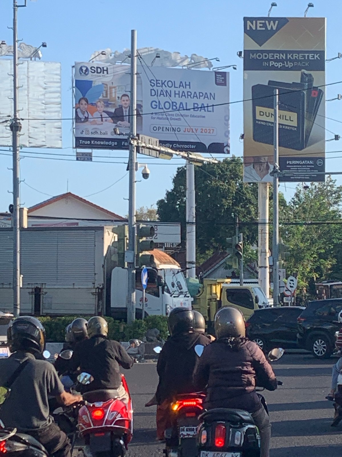 Scooters and traffic at a Denpasar Barat intersection