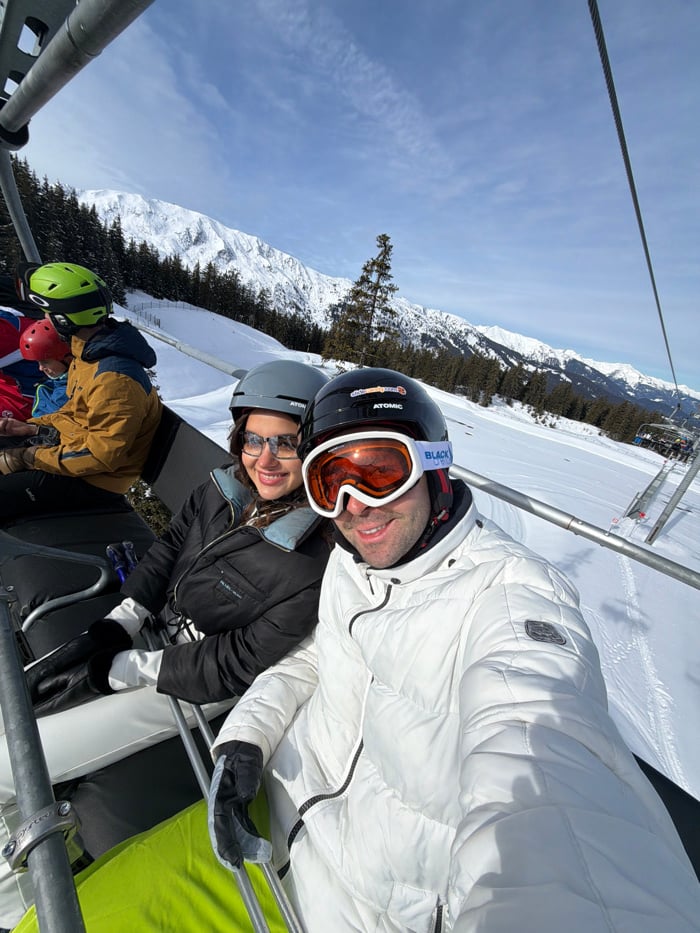 Skiers ride chairlifts at Les Allues resort under clear skies