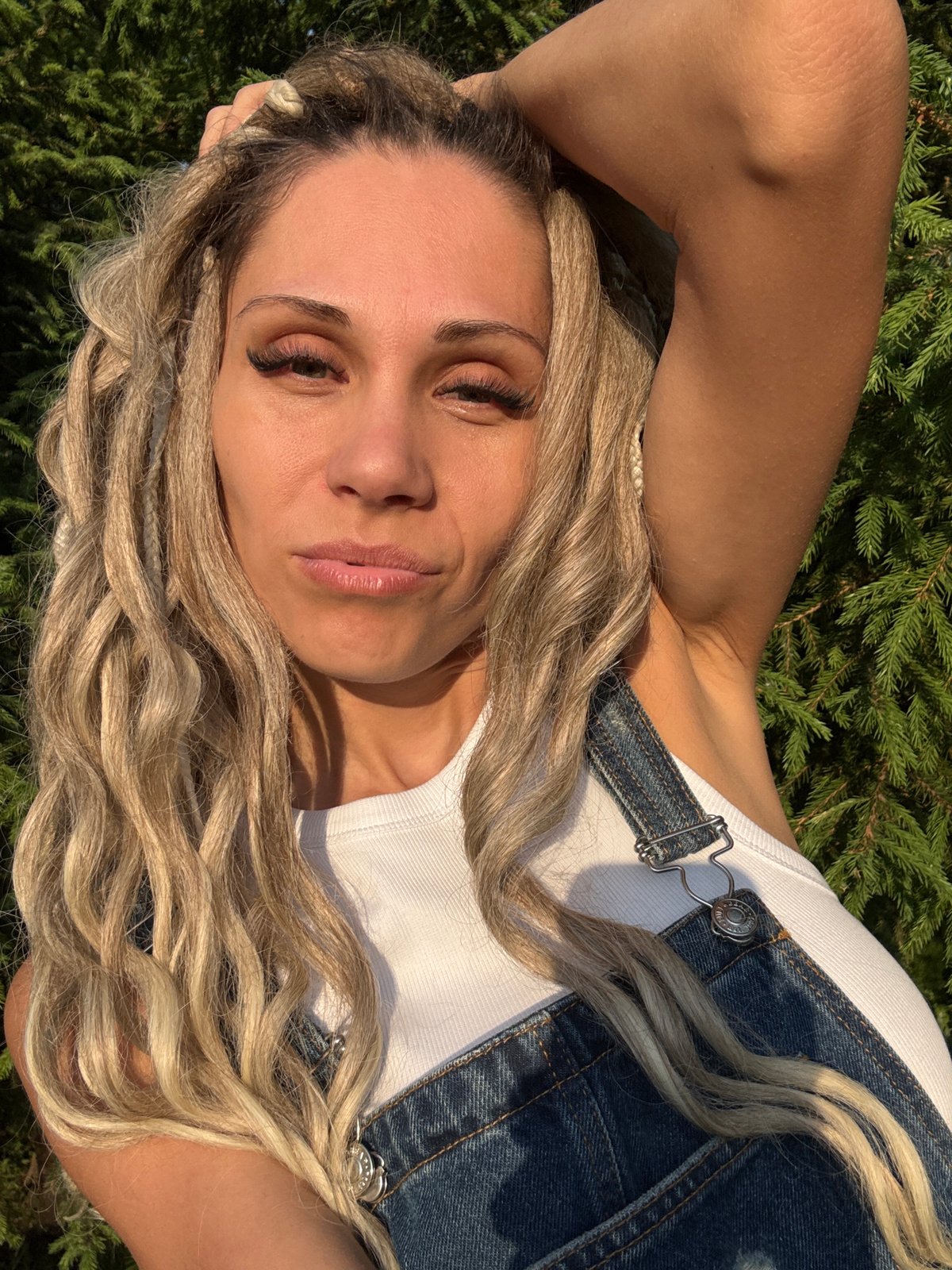 Woman photographs herself among trees and railway in Rusanovo