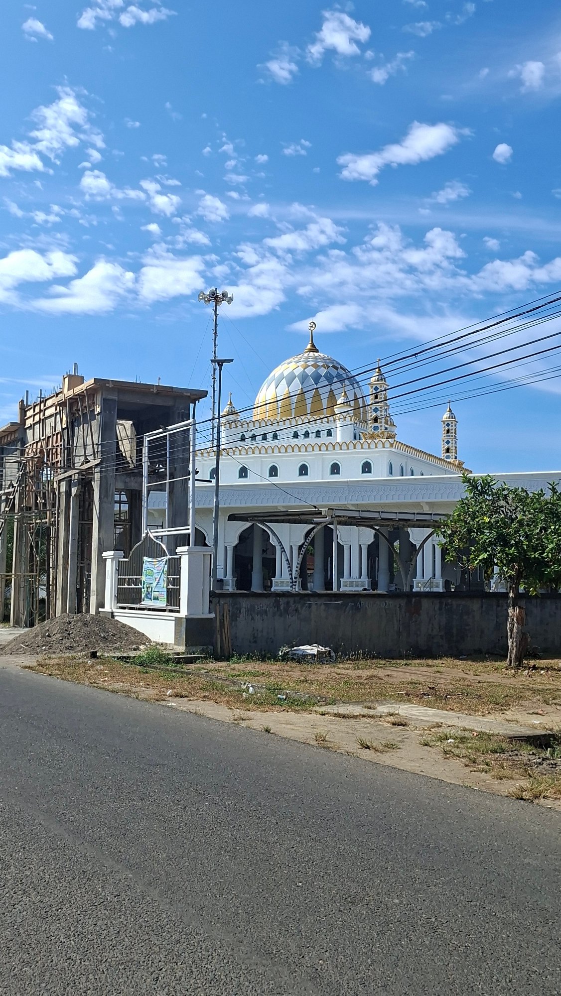 Hazy morning in Lhokseumawe — mosque, construction, and street life