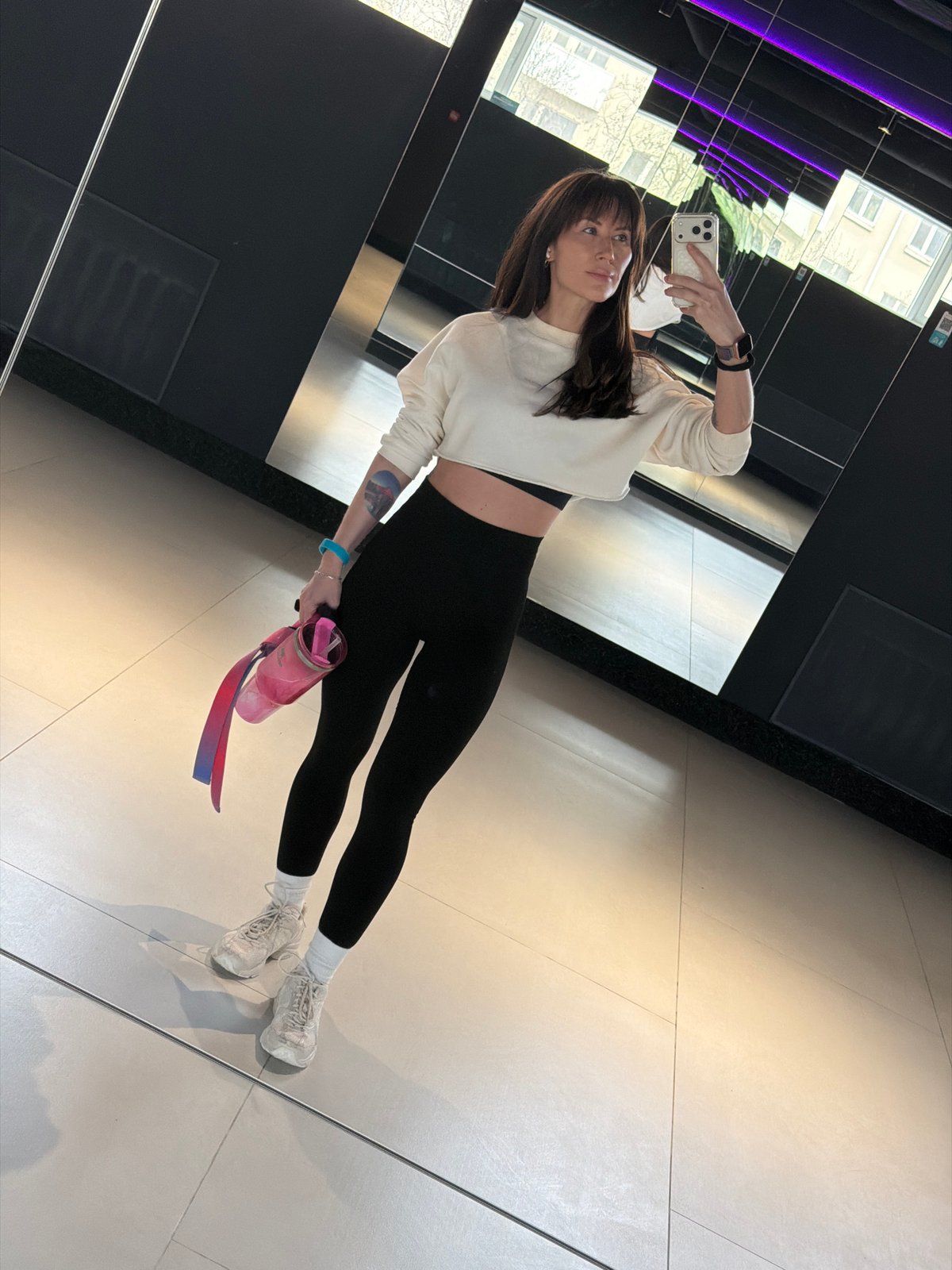 Woman takes mirror selfie with water bottle in Perm