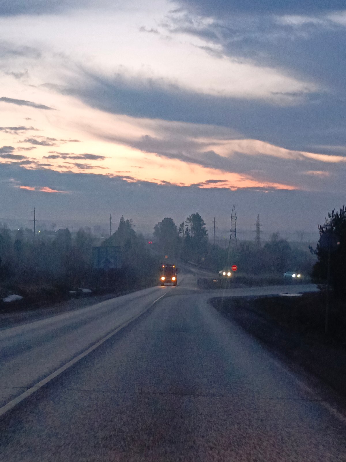 Truck travels rural road at dusk in Garevaya, Russia